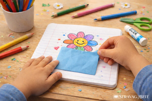 Bambini che realizzano il cartellone del Giardino della Memoria incollando i fiori salvati